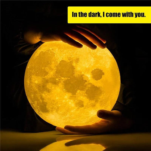 a person holding a yellow glowing moon night light lamp in their hands