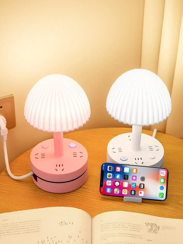 a table with a phone and a lamp on it