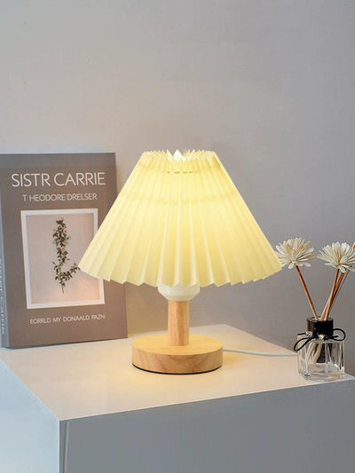 a bright lamp sitting on a table next to a book