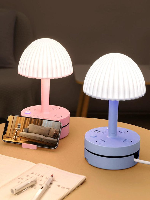 a table with two lamps and a cell phone on it