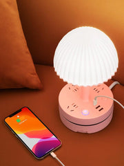  a cell phone is plugged into a lamp on a table