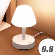 a white lamp sitting on top of a wooden table