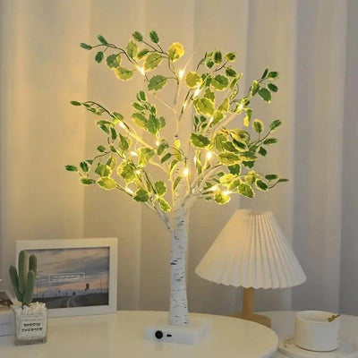 a white table topped with a white lamp and a tree