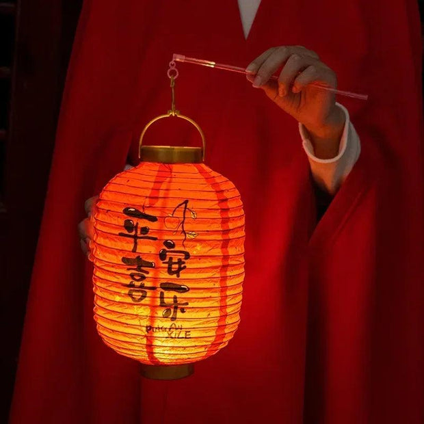 a person in a red robe holding a lantern