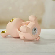 a pink pig laying on its back on a table