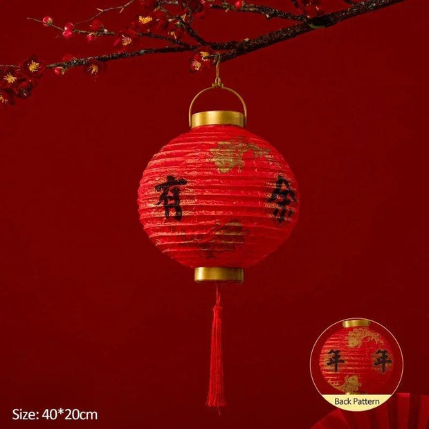 a red paper lantern hanging from a tree branch